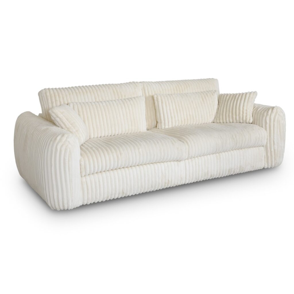 Canapé design cocooning en velours côtelé crème avec coussins de soutien.